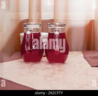 Deux cruches en verre de jus de canneberge sur la table Banque D'Images