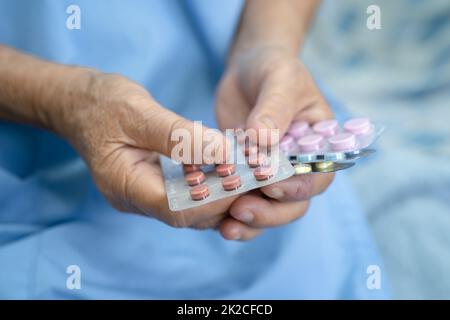 Asiatique senior ou âgée vieille femme patiente tenant des antibiotiques capsule pilules dans l'emballage blister pour le traitement infection patient à l'hôpital, pharmacie concept de pharmacie. Pharmacie concept pharmacie. Banque D'Images