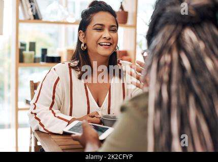 Nous avons tous besoin d'un rattrapage de taille, de temps en temps. Photo de deux jeunes femmes discutant dans un café. Banque D'Images