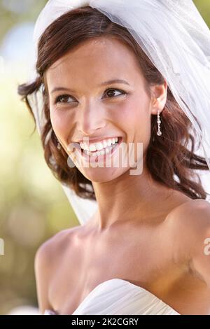 Shes une mariée qui se précipite. Magnifique jeune mariée regardant loin dans sa robe de mariage et voile. Banque D'Images