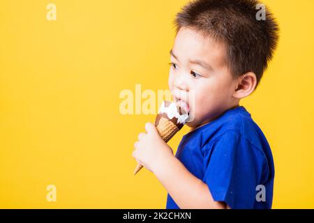 enfant mignon petit garçon rire attrayant sourire jouant des cales et manger doux chocolat glace gaufre cône Banque D'Images