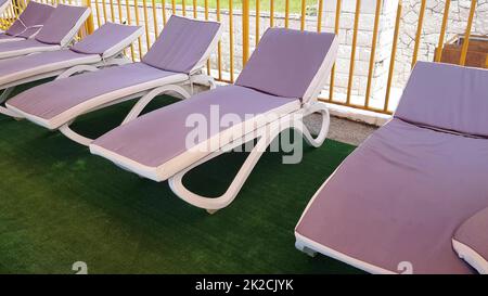 des chaises longues vides se tiennent dans une rangée sous le toit du solarium pour prendre des bains d'air sur la mer, une station de vacances Banque D'Images