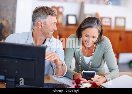 Il semble que nous ayons de l'argent supplémentaire à dépenser ce mois-ci. Photo d'un couple marié mature qui traverse ses finances à la maison. Banque D'Images