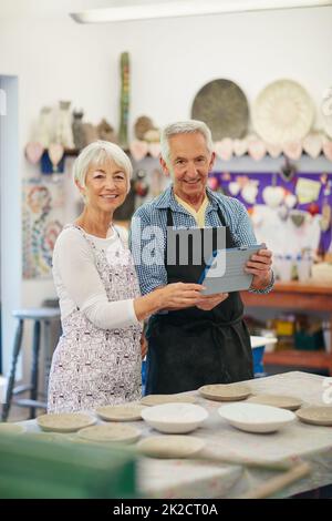 Notre activité de poterie en ligne est maintenant en direct. Photo d'un couple senior travaillant avec la céramique dans un atelier. Banque D'Images