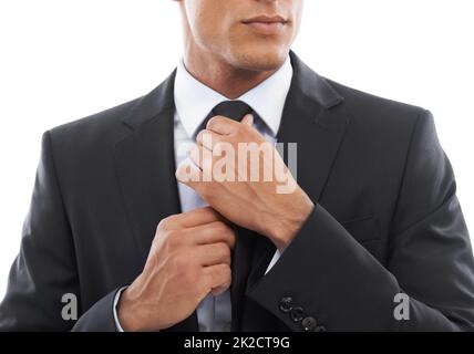 Se préparer Image rognée d'un homme d'affaires fixant sa cravate sur un fond blanc. Banque D'Images