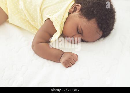 Dormir paisiblement. Plan court d'une petite fille endormie sur un lit à la maison. Banque D'Images