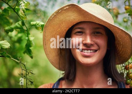 Je suis le plus heureux lorsque je suis dans les champs. Portrait d'une jeune agricultrice attrayante posant à l'extérieur dans les champs de sa ferme. Banque D'Images