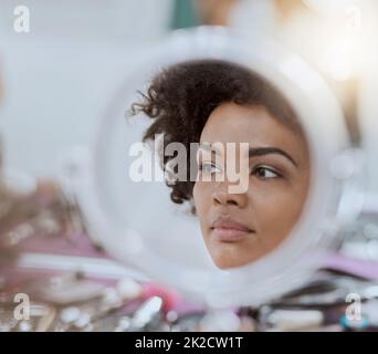 Dans la vanité. Plan court d'un reflet d'une jeune femme attrayante pendant que son maquillage est fait. Banque D'Images