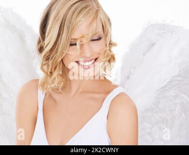 Ange céleste. Photo studio d'une belle jeune femme portant des ailes d'ange. Banque D'Images