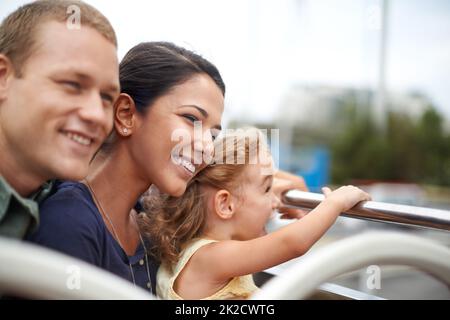 Une famille est un petit monde créé par l'amour. Une jeune famille qui voit la ville en haut d'un bus. Banque D'Images