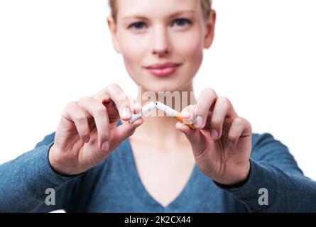 C'est ça - mi terminé. Un court studio photo d'une belle jeune femme qui casse une cigarette en deux. Banque D'Images