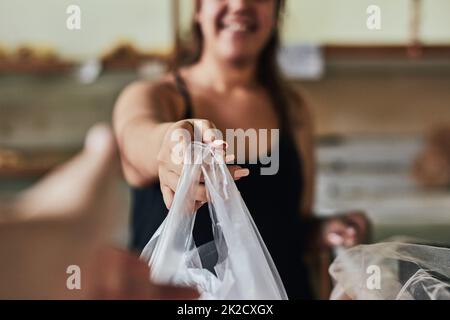 J'espère que vous apprécierez. Photo d'une jeune femme travaillant dans sa boulangerie. Banque D'Images