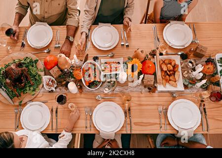 Rassemblez-vous autour de la table, son temps de donner Merci. Prise de vue en grand angle d'un groupe d'amis ayant un repas de Thanksgiving ensemble. Banque D'Images