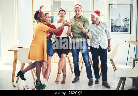 Nous avons fait de la magie au bureau. Photo d'un groupe d'hommes d'affaires créatifs qui se rassemblent pour fêter ensemble leur fête de Noël au bureau. Banque D'Images