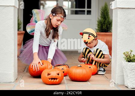 Des temps effrayants sont en route. Photo de deux adorables jeunes frères et sœurs jouant ensemble sur Halloween à la maison. Banque D'Images