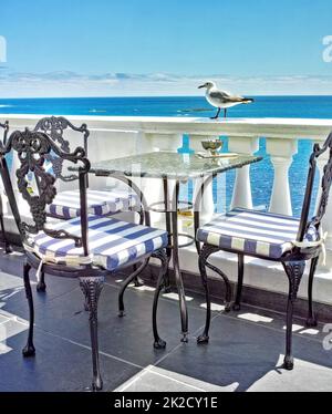 Vacances à la rive. Tables et chaises sur le balcon d'un restaurant en bord de mer. Banque D'Images