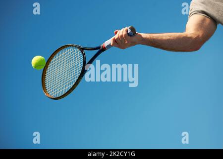 Et retour. Photo d'un bras heurtant une balle de tennis avec une raquette. Banque D'Images