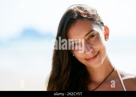 Les rouages sont féroces. Gros plan d'une belle jeune femme posant sur la plage. Banque D'Images