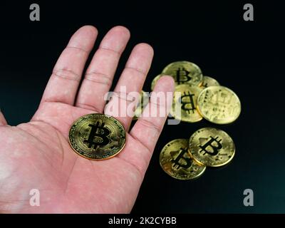 bitcoin placé sur la main sur un fond noir Banque D'Images
