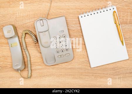 Téléphone vintage et ordinateur portable vierge sur fond en bois Banque D'Images