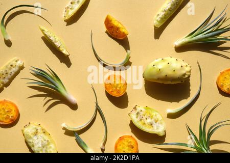 Exotic fruits, yellow and orange prickly pears. Healthy cactus fruits on lime green, orange backdrop. Direct sunlight with shadows Stock Photo