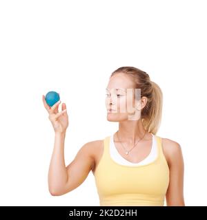 Faire bon usage de son ballon de stress. Vue rognée d'une femme qui exerce une pression sur un ballon de stress sur un fond blanc. Banque D'Images