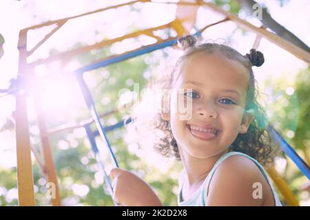 Prenez-moi si vous le pouvez. Photo d'une adorable petite fille sur le terrain de jeu. Banque D'Images