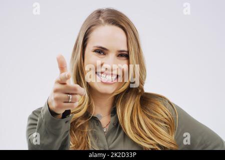 Vous avez vraiment bien compris. Portrait d'une belle jeune femme pointant vers l'appareil photo sur un fond gris. Banque D'Images