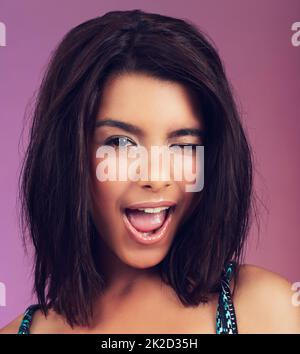 Hé vous. Photo studio d'une belle jeune femme posant sur un fond coloré. Banque D'Images