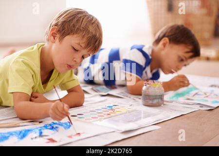 Libérer leurs artistes intérieurs. Photo de deux jeunes garçons en train de peindre des photos à la maison. Banque D'Images