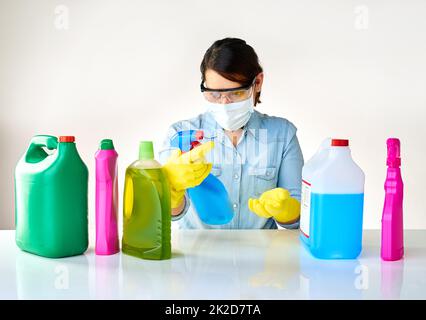 Je ne peux pas croire tous les produits chimiques dans cela. Plan court d'une jeune femme tenant plusieurs bouteilles de détergents. Banque D'Images