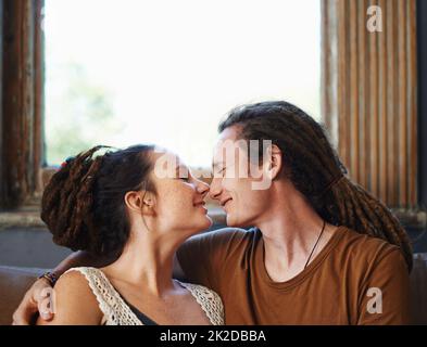 L'amour de l'enliseuse. Photo d'un couple affectueux et enfermé à la lecture, assis à la maison. Banque D'Images