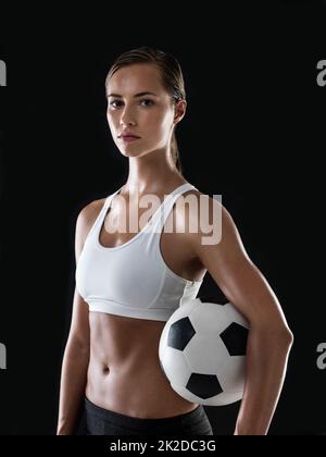 Prêt à faire rouler la balle. Portrait d'une jeune femme athlétique prête à jouer au football. Banque D'Images