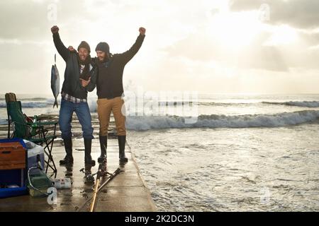 La bromance fleurit au cours d'un voyage de pêche. Photo de deux jeunes hommes pêchant sur un quai. Banque D'Images