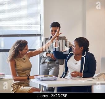 Nous faisons une équipe formidable. Photo d'un groupe de collègues de sexe féminin se réunissant dans un bureau. Banque D'Images