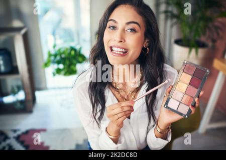 Cette palette est indispensable. Photo d'un influenceur enregistrant un didacticiel de maquillage pour son blog à la maison. Banque D'Images