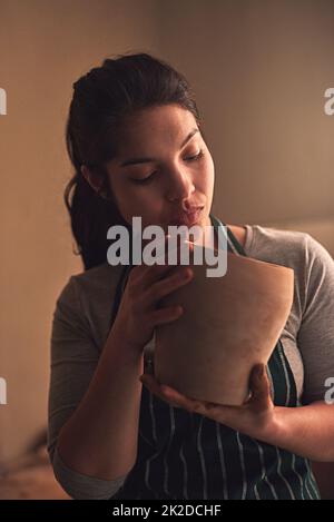 La perfection réside dans les détails. Photo d'une artiste en céramique travaillant sur sa poterie dans un atelier. Banque D'Images