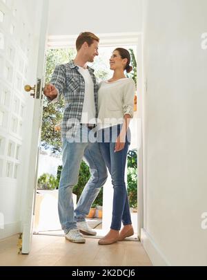 Propriétaires pour la première fois. Photo d'un jeune couple debout dans la porte de leur nouvelle maison. Banque D'Images