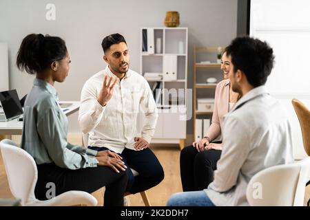 Deux personnes consolant le jeune homme pendant la thérapie de groupe Banque D'Images