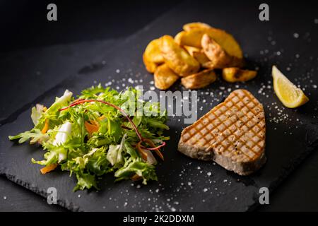 steak de thon avec salade et pommes de terre épicées Banque D'Images