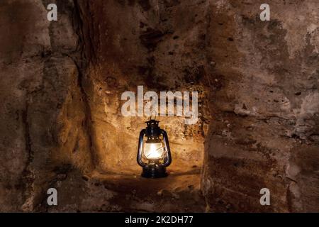 La lampe au kérosène brûle la nuit sur un piédestal dans une ruine du vieux château Banque D'Images