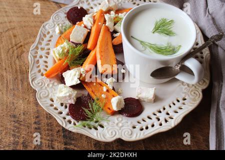 Betteraves, carottes grillées en bonne santé avec du fromage feta, salade de fenouil et du yaourt grec dans de petits bols en verre sur la table de bois rustique, vue du dessus Banque D'Images