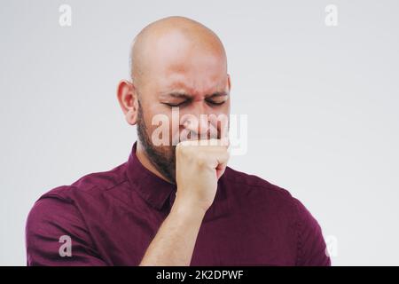 La bronchite n'est pas la meilleure. Studio photo d'un beau jeune homme toussant sur fond gris. Banque D'Images