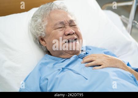 Asiatique senior ou âgée femme âgée sentir la douleur dans la poitrine et le coeur sur le lit dans la salle d'hôpital de soins sains concept médical fort. Banque D'Images