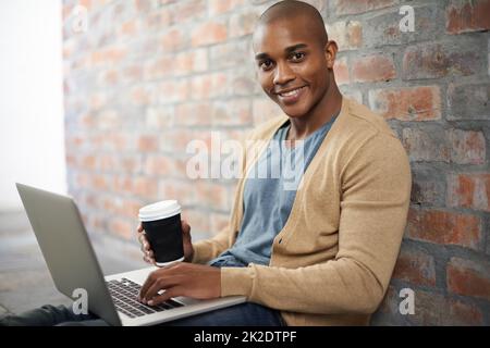 Il est facile à travailler lorsque vous vous sentez à l'aise. Photo courte d'un beau jeune homme travaillant sur un ordinateur portable. Banque D'Images