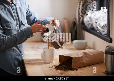 Sa première tasse le matin. Une jeune femme qui fait du café. Banque D'Images