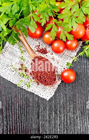 Tomates séchées dans une cuillère sur une planche en bois Banque D'Images