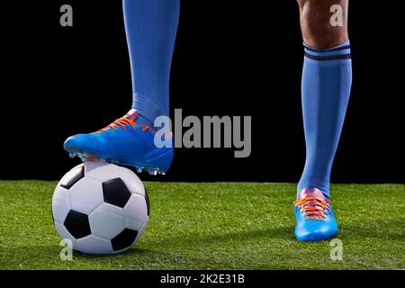 Allez à l'objectif. Plein studio tourné d'un jeune joueur de football beau isolé sur noir. Banque D'Images