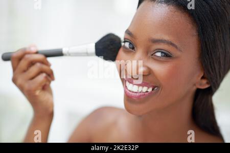 Ajouter la touche finale de la fabulosité. Photo d'une belle jeune femme appliquant du blush avec une brosse à maquillage. Banque D'Images