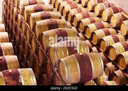 Attendre jusqu'à ce que le temps soit bon. Fûts de vin rouge stockés dans une cave à vin. Banque D'Images